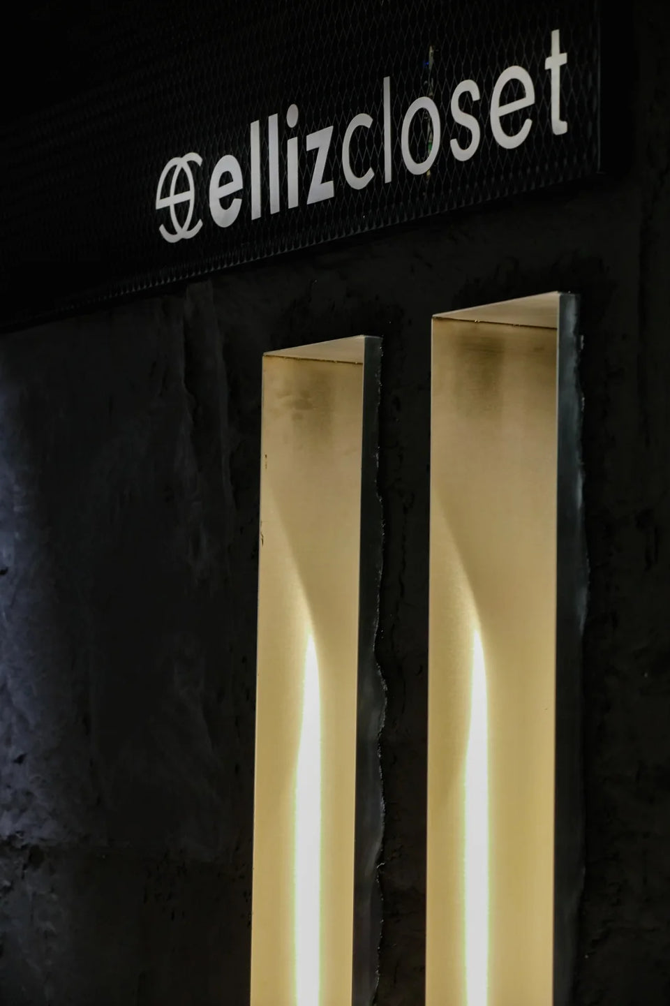 Το λογότυπο ELLIZ CLOSET σε μαύρο τοίχο